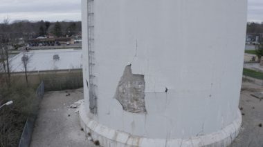 The base of a water tower. Part of the paint is peeling off in a large section