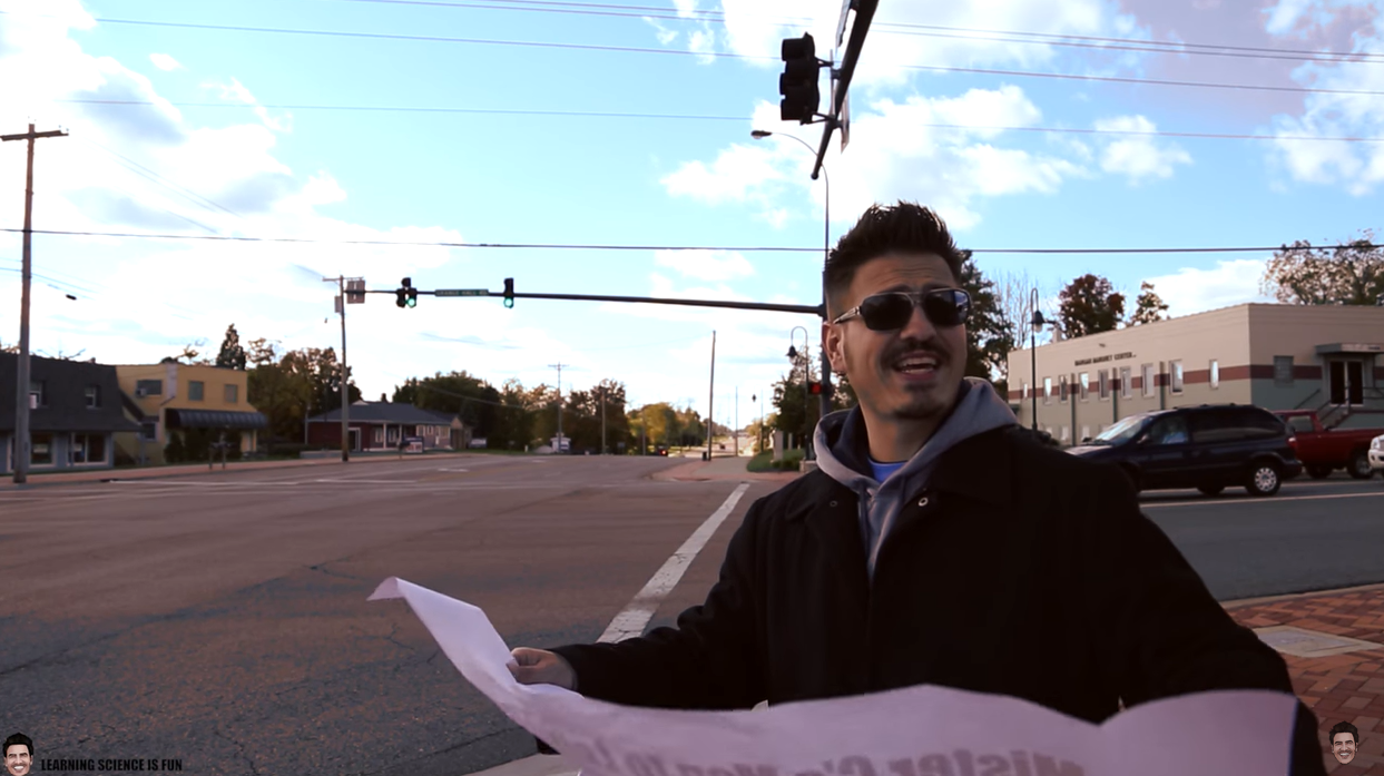Mr. C holding a map at a crosswalk.