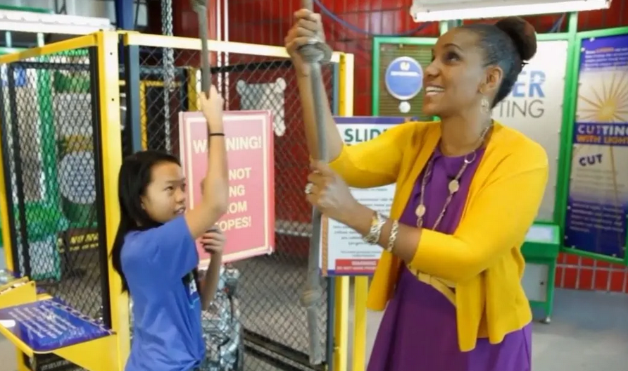 A student and museum curator standing in a science exhibit