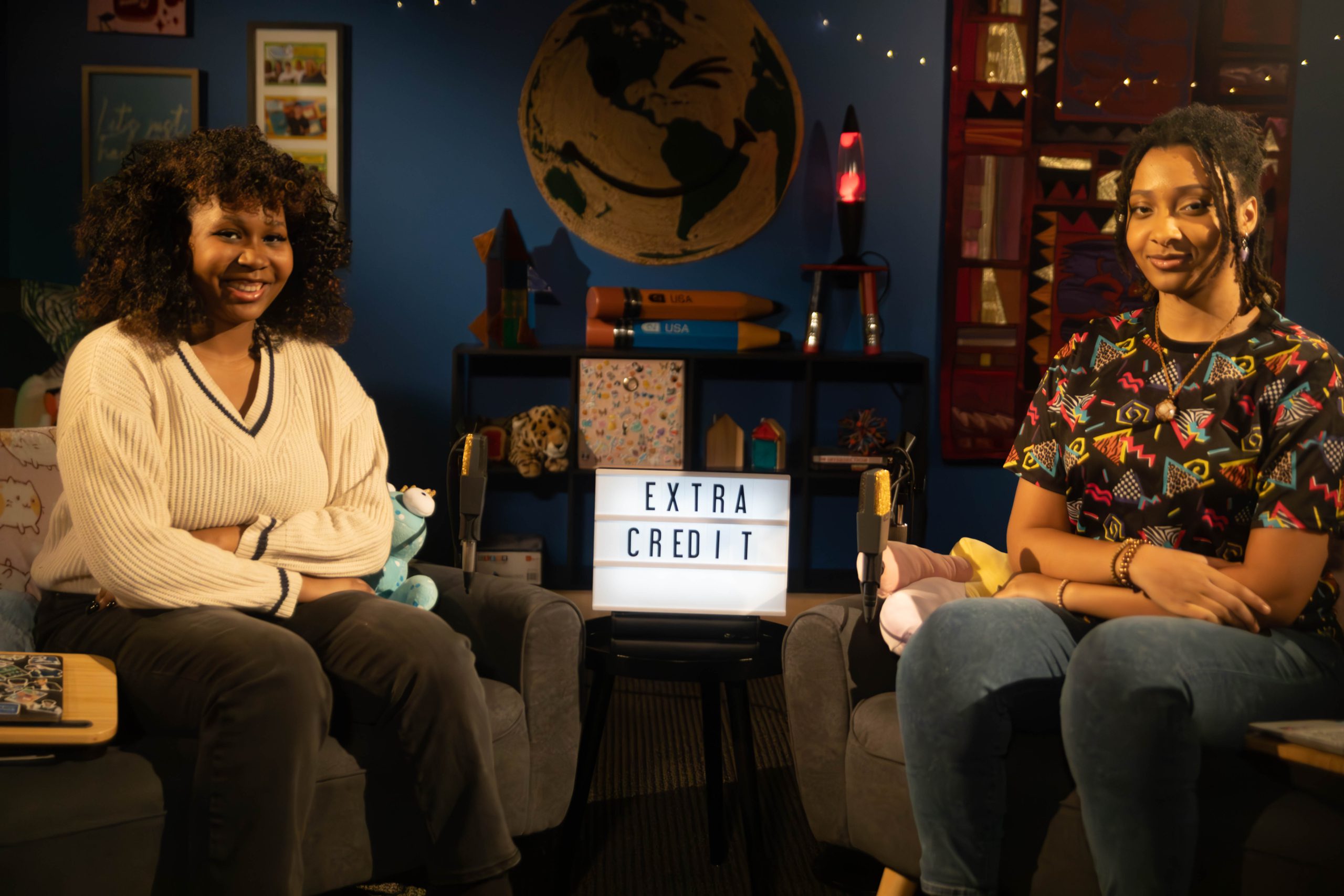 Extra Credit hosts Brooke and Paige sitting on opposite couches