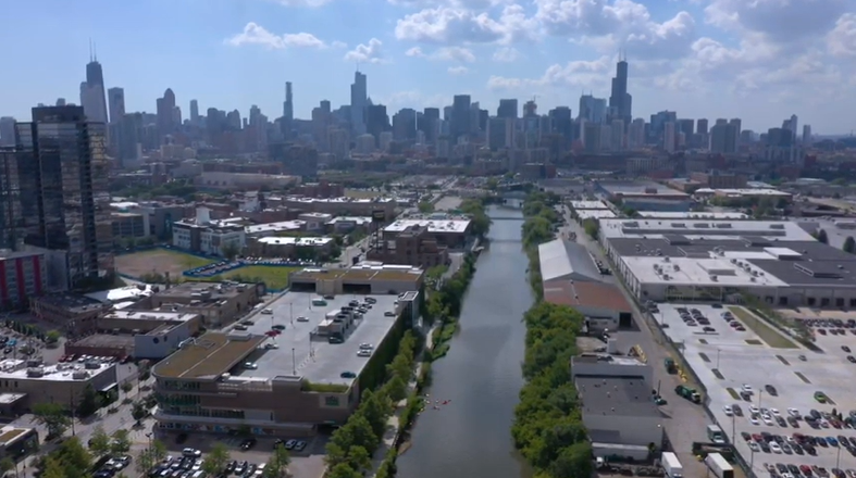 Aerial shot of a city. A river runs down the middle.