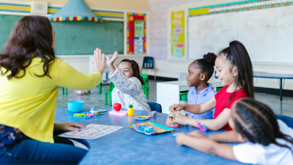 teacher and group of kids high fiving