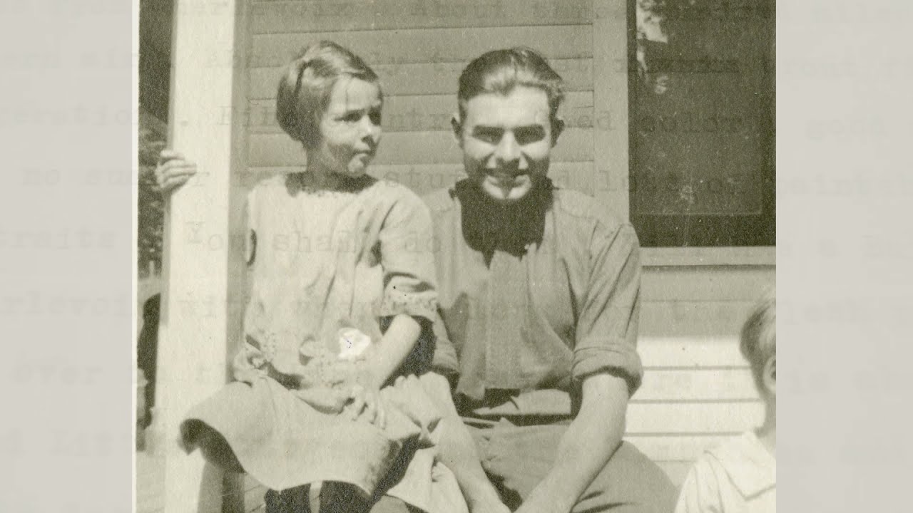 black and white photo of a teenager and child sitting on a front porch